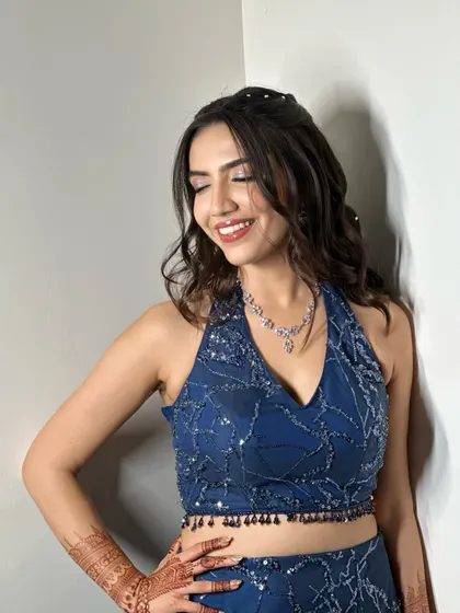 A joyful, smiling portrait. This sangeet look is all about fun and glamour, with sparkling eyes, a bold red lip, and a radiant, happy glow.