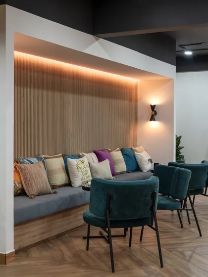 A cozy built-in seating nook with warm backlighting and plenty of cushions. This is a perfect spot for a quick team sync-up or a quiet moment to work away from a desk.