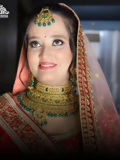 A happy bride looking up, showcasing her elegant eye makeup and the beautiful details of her bridal jewellery.