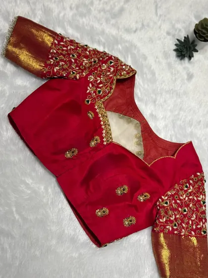 The front view of the red bridal blouse, with heavy embroidery on the sleeves and delicate work on the neckline.