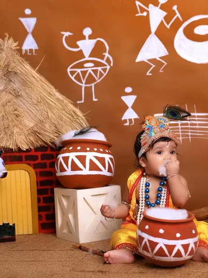 A mischievous and adorable moment from a Janmashtami session. This little one is caught tasting the 'butter', resulting in a cute and candid photo.