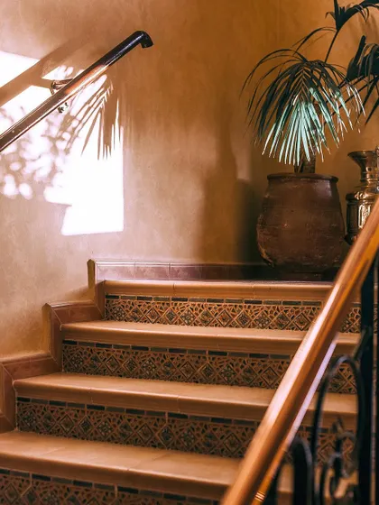 Even a staircase landing can be a perfect spot for a green corner. A single, elegant palm in a rustic pot adds life and a touch of sophistication to this indoor space.