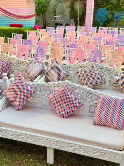 Close-up of the traditional carved white benches with colorful patterned cushions, adding a touch of Indian heritage.