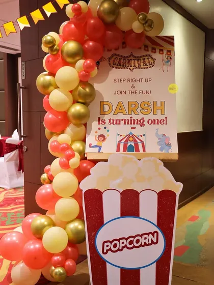 "Step right up and join the fun!" The entrance to Darsh's first birthday carnival featured a welcoming balloon arch and a fun popcorn prop to get guests excited for the celebration.
