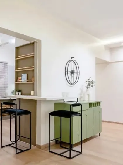 An open-plan living and dining area from the Sobha Daffodil project. The design connects the kitchen to the living space with a breakfast bar, while a green console adds a pop of color.