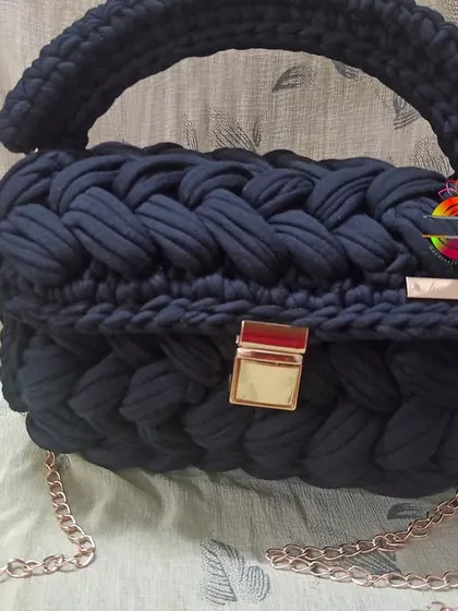 The black t-shirt yarn handbag, a timeless and elegant accessory. The deep black color makes the gold hardware pop, creating a sophisticated look for any occasion.