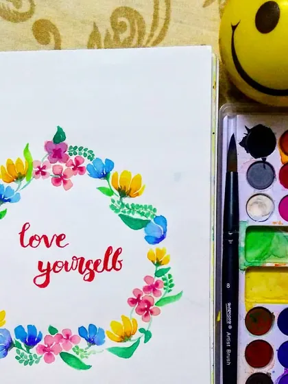 Another view of the "love yourself" floral wreath, showcasing the vibrant colors and loose floral style. This type of artwork makes a thoughtful and personal gift.