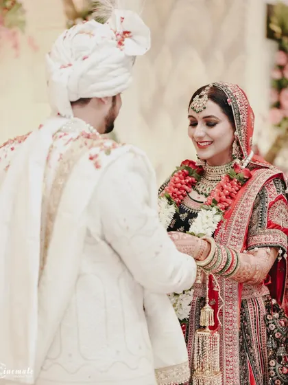 A beautiful moment during the wedding ceremony, capturing the couple's interaction and the intricate details of their traditional attire.