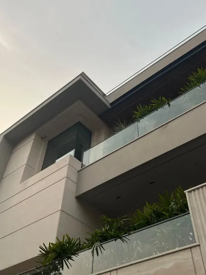 This upward-looking shot captures the clean, intersecting lines of the building's architecture. The composition of stacked volumes and transparent railings creates a sense of lightness and modernity.