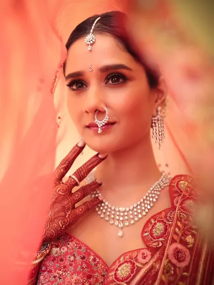A classic red bridal look will always be iconic. Peeking through the veil, this shot captures the soft yet regal glam I created for her, focusing on elegant eyes and a finish that feels both traditional and modern.