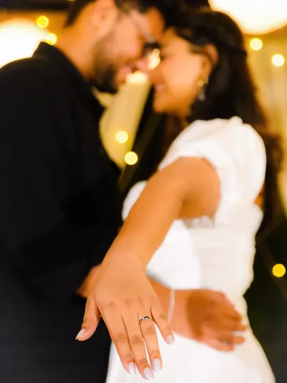 "She said yes!" This photo perfectly captures the post-engagement glow, with the ring-adorned hand in focus and the happy couple blurred softly in the background.