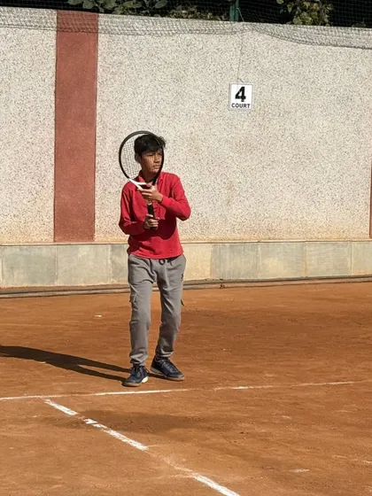 A young player waiting to receive a serve, showing focus and a solid ready position. Mental preparation is as important as physical skill.