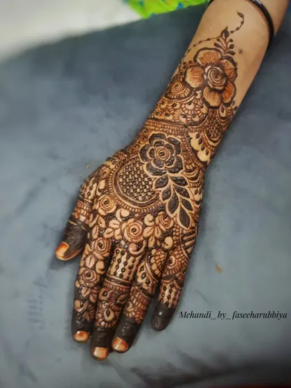 A close-up of the fresh henna paste application, showing the detail and precision.