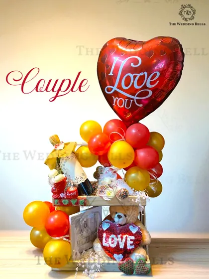 Love, wrapped in a hamper. This couple's hamper with a teddy bear, a mini wine bottle, and a heart-shaped balloon is perfect for an anniversary or just because.
