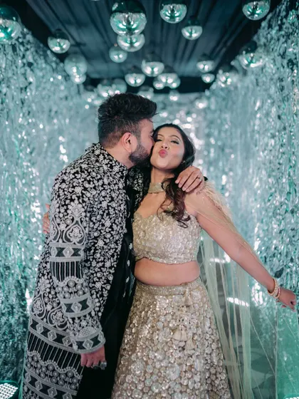 A fun and intimate moment between the couple in a glamorous, shimmering photo booth tunnel.