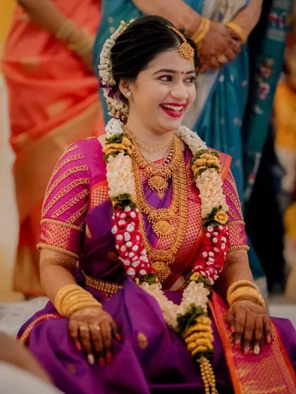 A portrait of a beautiful South Indian bride, her happy smile radiating joy during her engagement ceremony.