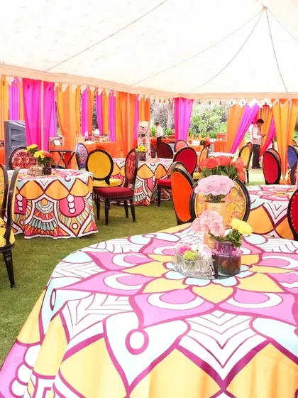 The decor is in the details. We used custom-printed tablecloths with vibrant patterns and multi-colored chairs to bring the "Rangeela Rajasthan" theme to life in the guest dining area.