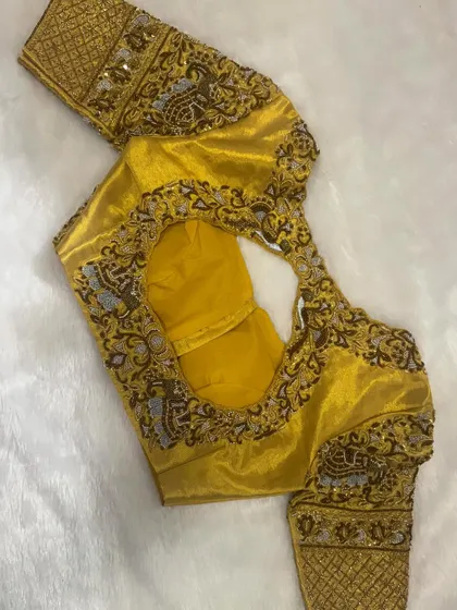 A closer look at the stunning hand-embroidered bridal blouse in gold, with intricate elephant and paisley motifs.