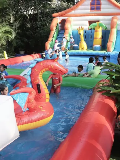 A wide view of the inflatable pool setup, complete with a large slide and floating toys. I can transform any outdoor space into a mini water park.