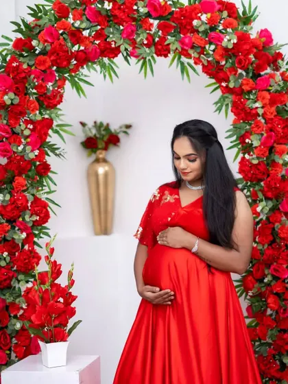 A beautiful portrait in our red maternity gown, framed by a matching floral arch.