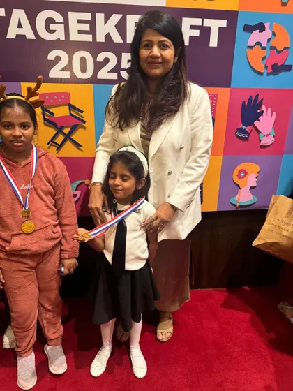 A teacher with her students, celebrating their wonderful performances and the joy of being on stage.