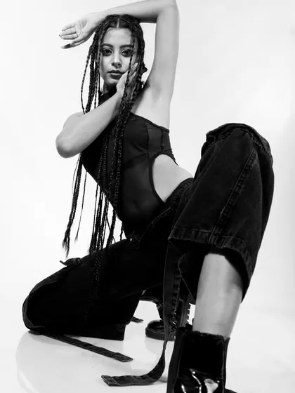 A dynamic crouching pose in black and white, highlighting the model's flexibility and the editorial style.