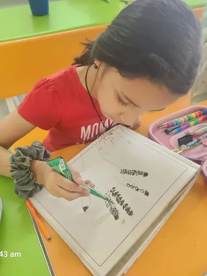 A student concentrates on her mehndi design during an art and craft session at our summer camp.