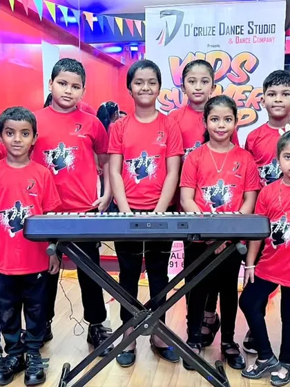 Our young musicians ready for their moment. The kids in our keyboard and vocals group stand proudly with their instrument before their performance at the camp showcase.