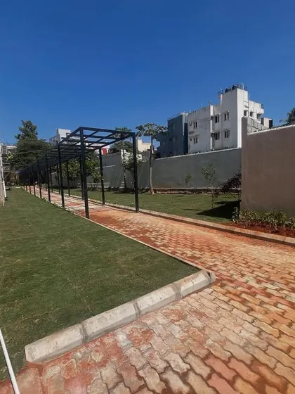 Another view of the apartment complex project, showing the long stretch of lawn and the pergola structure.