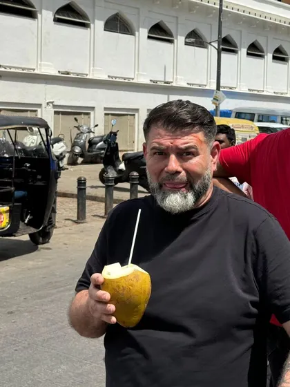Embracing the local culture. Chef Guram takes a break to enjoy fresh coconut water on the streets of India, fully immersing himself in the local experience before his exclusive dinner events.
