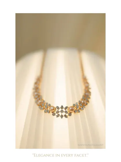 An elegant, minimalist shot of a diamond and pearl necklace, creatively photographed against a lampshade to highlight its delicate beauty.