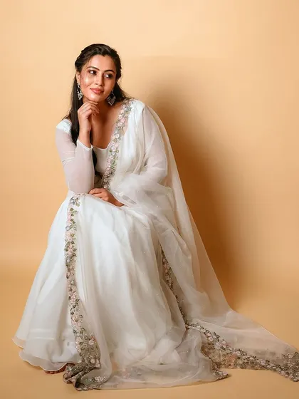 A beautiful white Anarkali gown with a delicately embroidered dupatta.