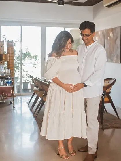 A full-length portrait of the couple in their home, creating a beautiful environmental portrait that tells the story of their life together as they await their baby.