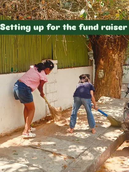 Getting ready for the big day. Children sweep the area to prepare for their fundraiser sale, learning that every task, big or small, contributes to the goal.