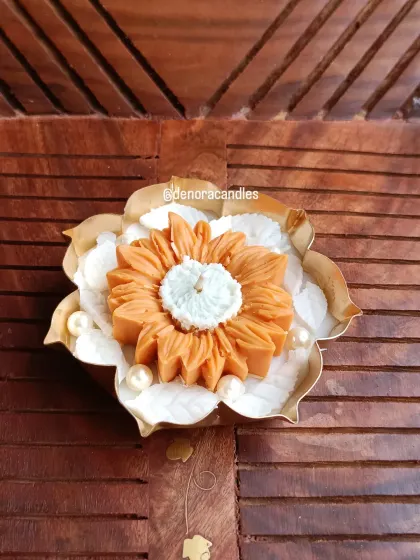 A single sunflower-style urli candle, featuring a large orange flower as the centerpiece.