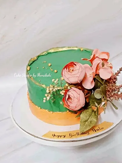 A beautiful birthday cake in a unique peach and green color combination. This no-fondant design is decorated with fresh flowers for a modern and artistic feel.