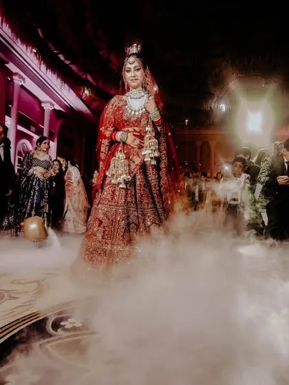 An epic, wide-angle shot of the bride's entrance, with dramatic backlighting and fog creating a truly cinematic scene.