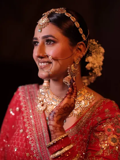 Prakriti looked absolutely divine in her red bridal lehenga. We paired it with traditional gold jewelry and a makeup look that was both classic and radiant, finished with a floral bun.