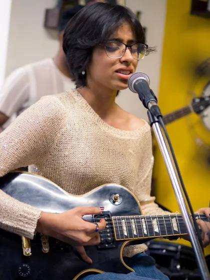 A close-up of Anushka, a talented singer-songwriter, during her set. Our stage is a platform for artists to express themselves and share their unique voice with the world.
