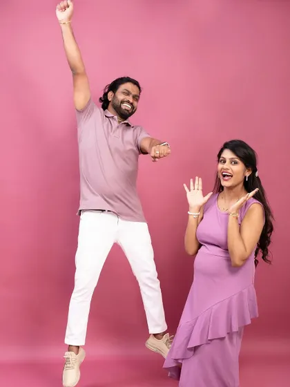 Pure excitement. This playful shot captures the super-excited dad-to-be jumping for joy next to his smiling partner.