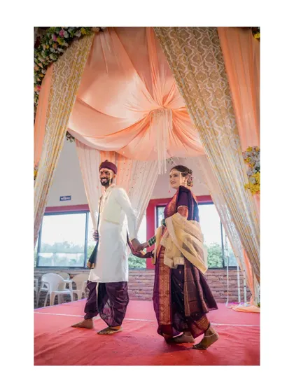 The bride and groom make their grand entrance, walking hand-in-hand down the red carpet.