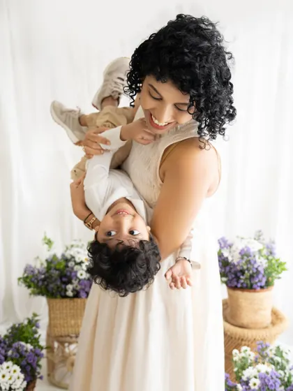 An energetic shot of a mother holding her son upside down. His happy face says it all!