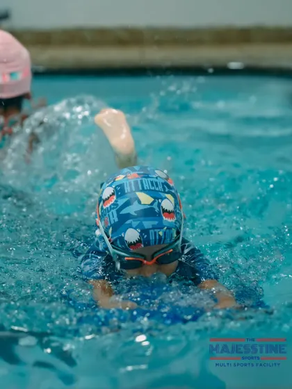 Practice makes perfect. A young swimmer uses a kickboard to build leg strength and improve his form, a fundamental part of our training program.