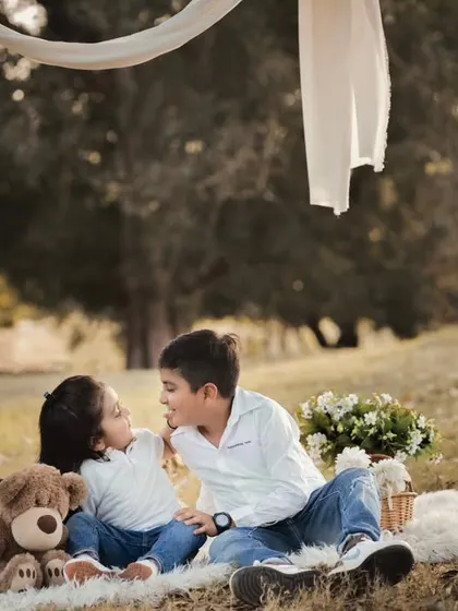 A sweet, candid moment between a brother and sister during an outdoor picnic shoot. We create a relaxed environment where kids can just be themselves, allowing us to capture their natural bond.