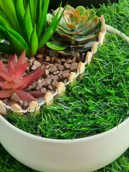 A beautiful artificial succulent Zen garden in a round white ceramic bowl. The different colours and textures of the succulents create a lovely, low-maintenance arrangement that makes a great gift.