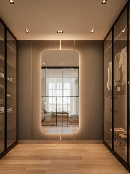 This is what couple closet goals look like. We designed this walk-in closet to be a dreamy, organized space, complete with a large, backlit mirror that adds a touch of glamour and makes the space feel larger.