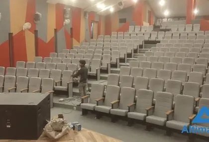 An engineer works on the final connections for the stage's audio system. This phase is critical for ensuring all sound equipment, from microphones to subwoofers, is perfectly integrated and calibrated for the room's acoustics.