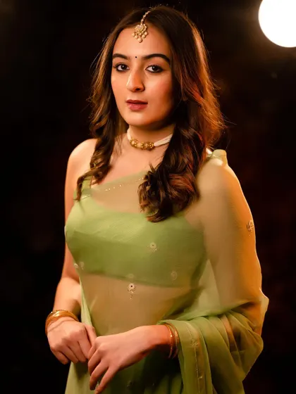 A direct-to-camera look from the same series. The lighting highlights the delicate fabric of the saree and the model's features.