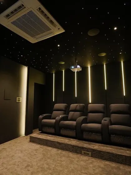 This wide shot shows the full layout of the Chennai home cinema, including the raised seating platform and the ambient lighting design that enhances the room's modern aesthetic.