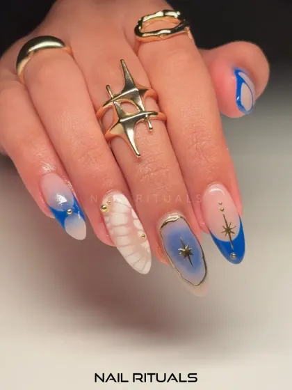 Ethereal nails that dance with shades of blue. This shot showcases the intricate details of the star designs and the delicate, dreamy patterns.